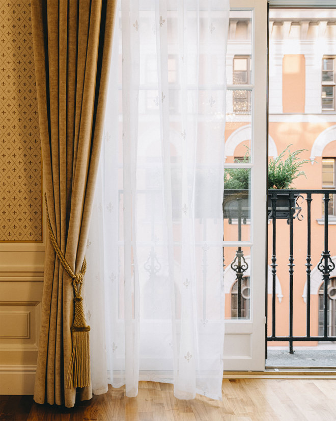 Åpen dør til balkong på et rom på Hotel Bristol. Foran balkongdøren henger en hvit, lett gardin, samt en tykkere gardin foran