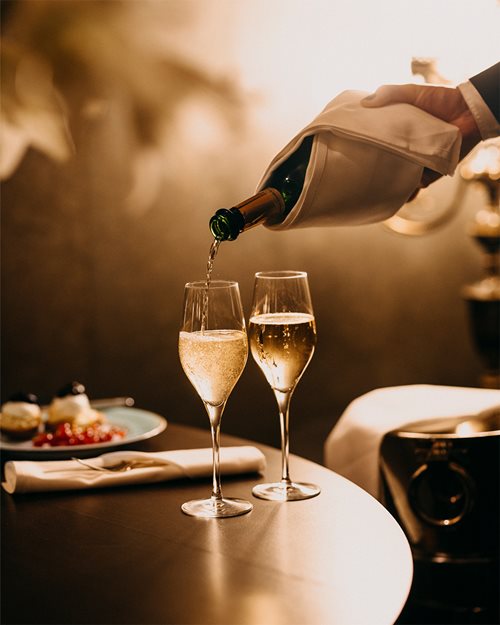 Champagne helles i glass av servitør på Hotel Bristol